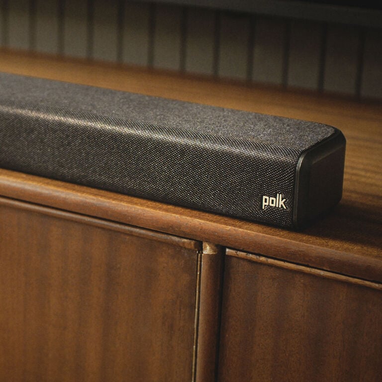 A closeup of a soundbar on a tv stand