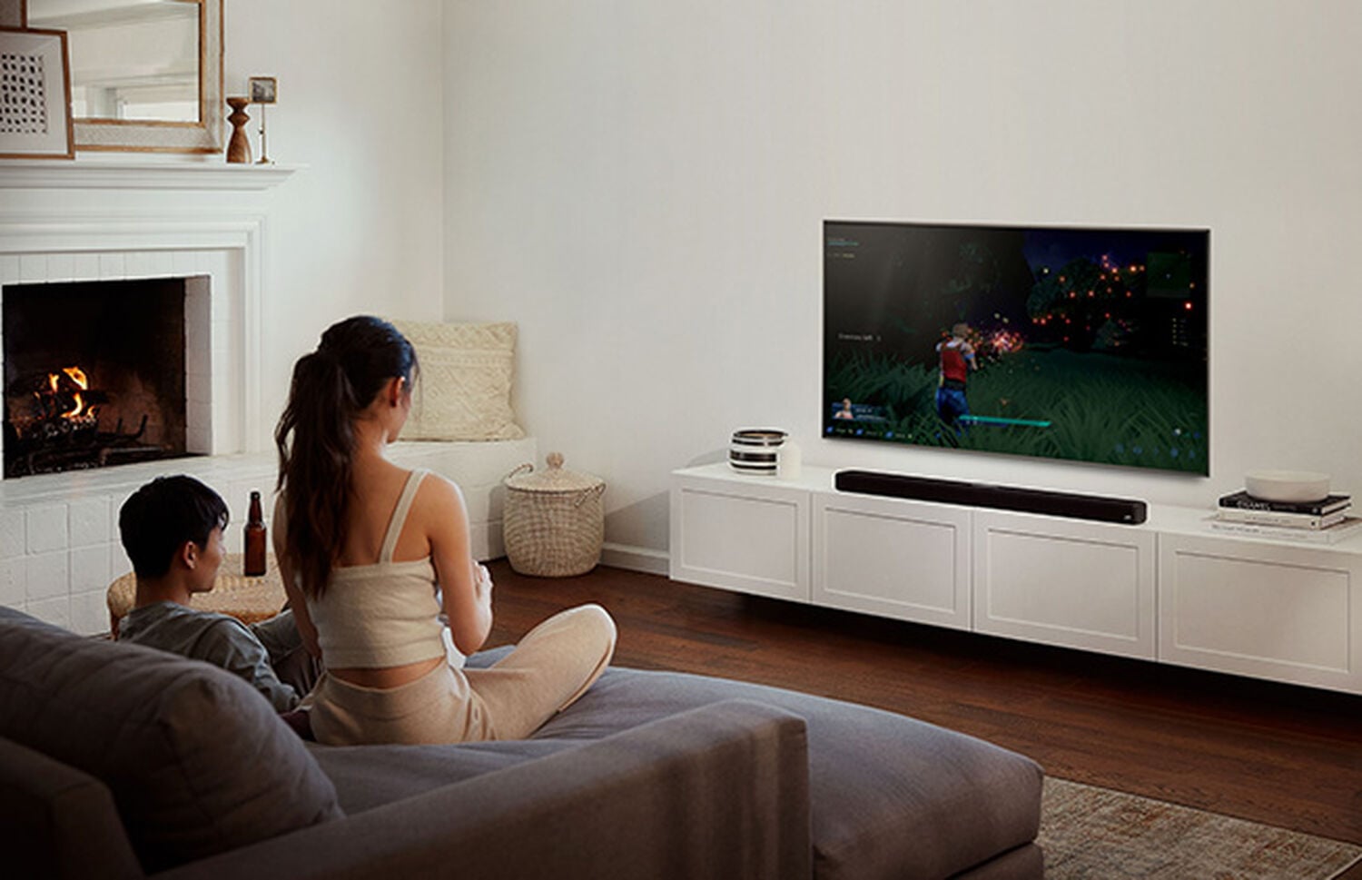 A man and woman watching tv with a Signa Series sound bar